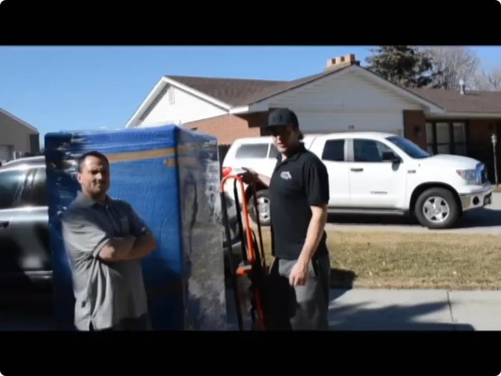 Movers preparing household items for transport